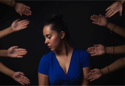 woman surrounded by hands offering help