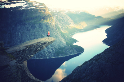 woman doing yoga on a ledge over a river gorge